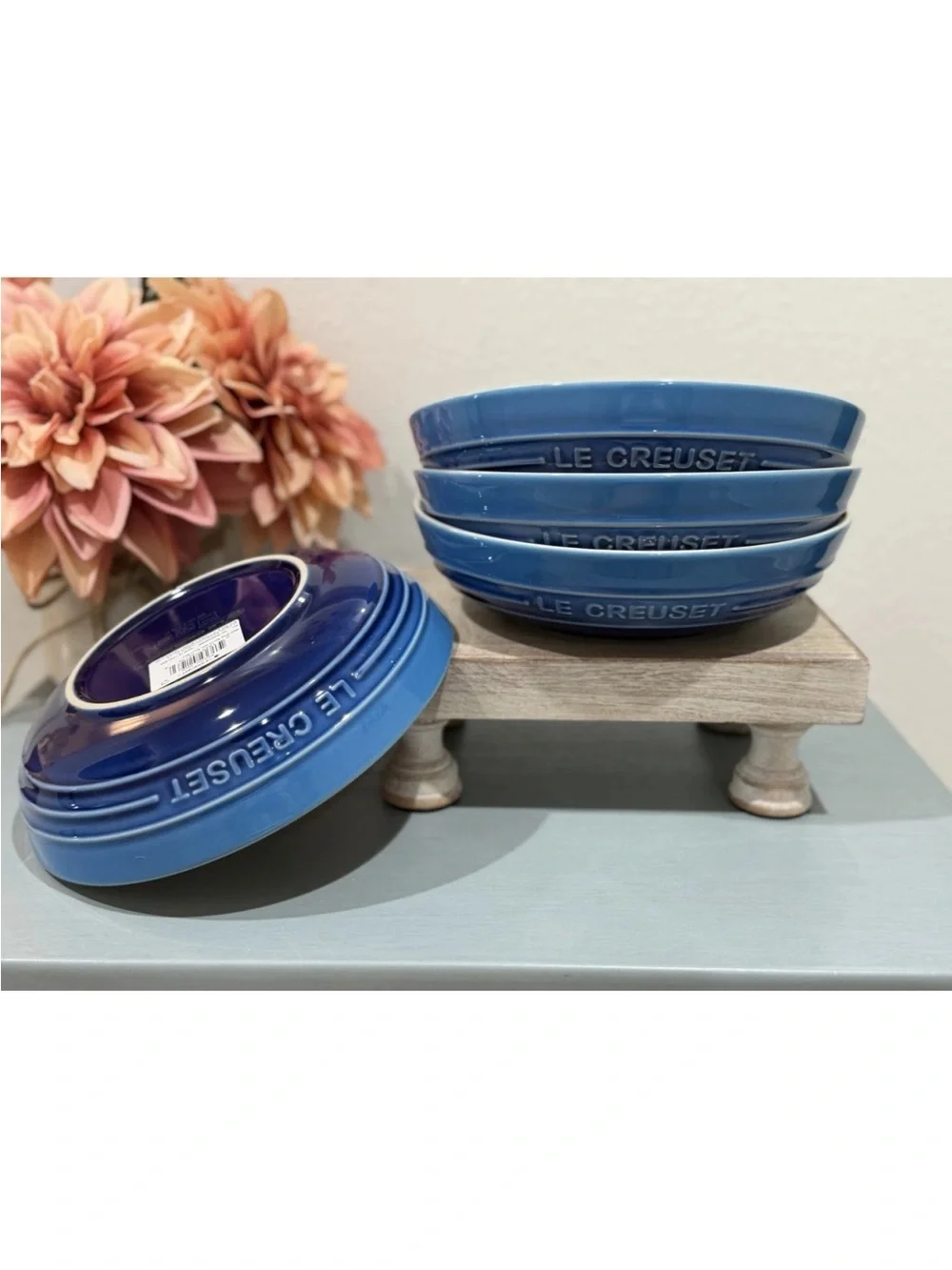 The product is a set of 4 Le Creuset deep round dish plates in a striking azure